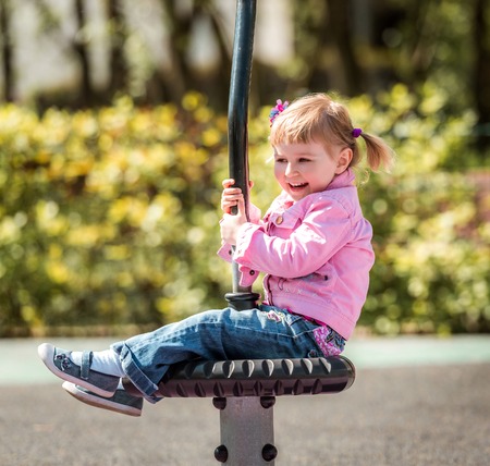 Cute little girl on outdoor playground equipmentの写真素材