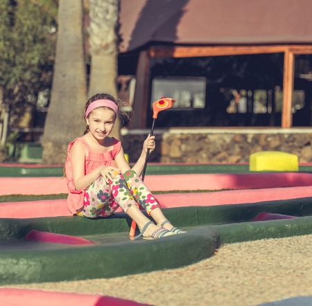 Cute smiling little girl playing golfの写真素材
