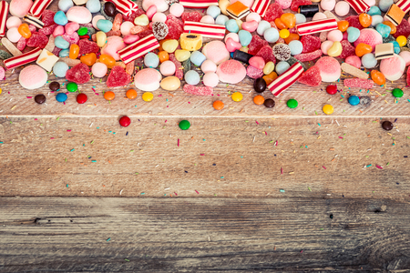 variety of candies on a wooden background with space for textの写真素材