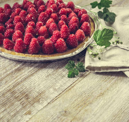 Tart with raspberries on a wooden background with space for text.の写真素材