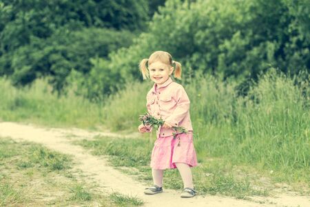 Cute little girl on the meadow in summer dayの写真素材