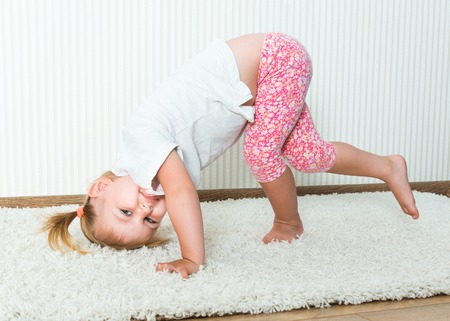 2-year-old girl engaged in physical activity at homeの写真素材