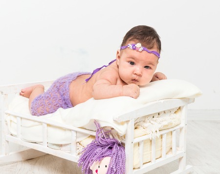 two-month-old girl in fishnet panties lying in bedの写真素材