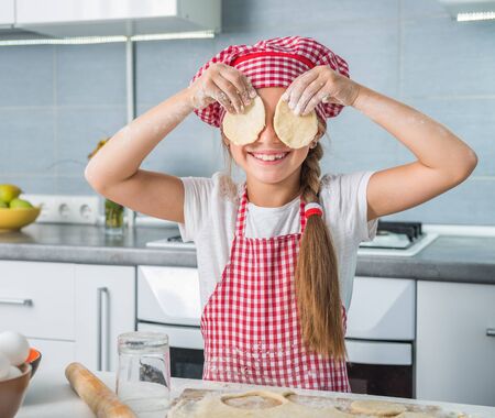 cut little girl having fun with pieces of dough