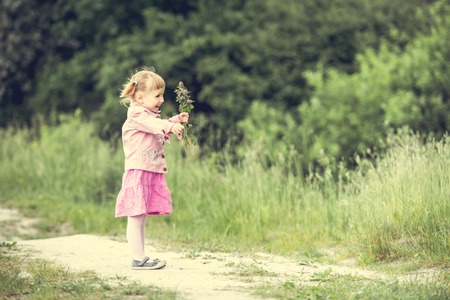 Cute little girl on the meadow in summer dayの写真素材