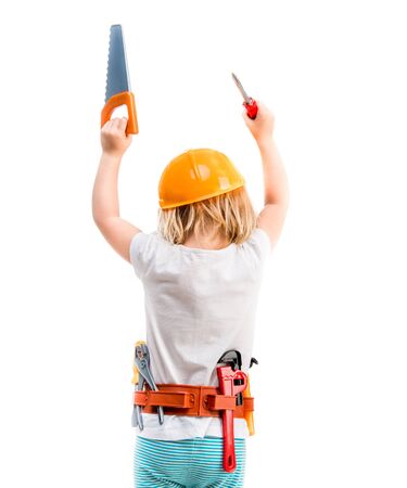 little child with helmet and hands up with instruments from backの写真素材