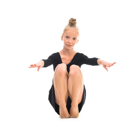 little gymnast stretching on the floor isolated on white backgroundの写真素材