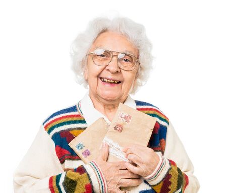 elderly woman holding old envelops isolated on white backgroundの写真素材