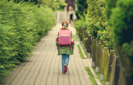 little girl with a backpack going to school. back viewの写真素材