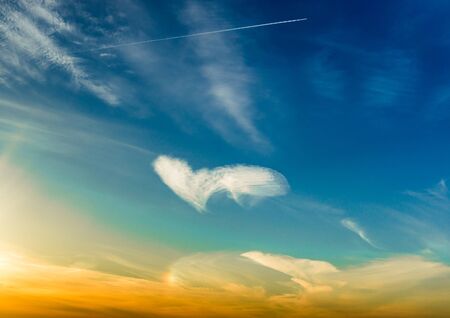 White clouds making a heart shape againt a blue skyの写真素材
