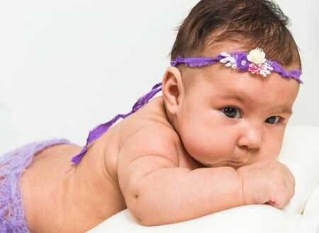 two-month-old girl in fishnet panties lying in bed