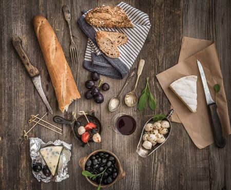 French breakfast. Different types of cheese, wine and other ingredients on a wooden tableの写真素材