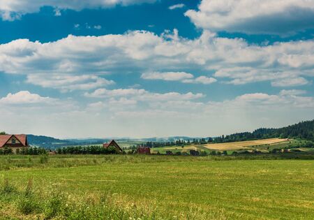 green field under the beautiful cloudsの写真素材