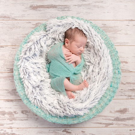 newborn baby peacefully sleeping in round cot with fluffy blanket, top viewの写真素材