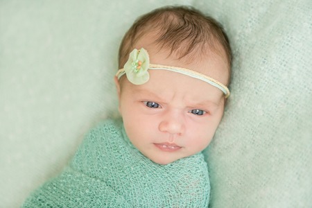 beautiful newborn girl in green close-upの写真素材