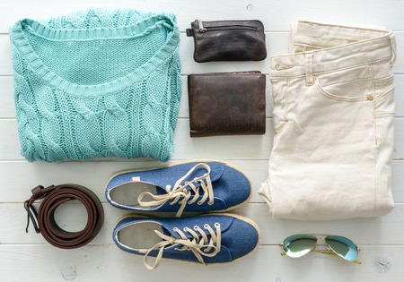 carefully folded woman casual closes and accessories on wooden table top viewの写真素材