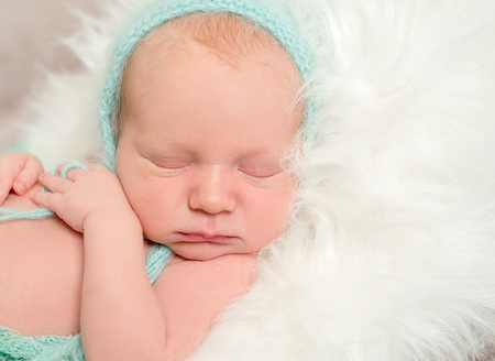 funny asleep baby face in hat, closeupの写真素材