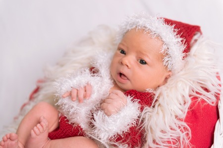 Infant dressed as Santa Claus