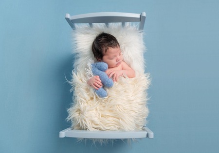 Baby cuddling with his toy, topviewの写真素材