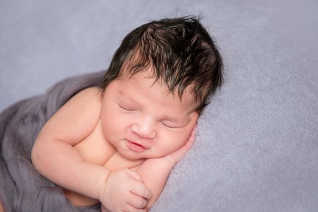 Hairy baby napping on his side, closeupの写真素材