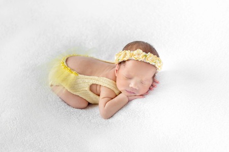 Baby dressed in a yellow outfit sleepingの写真素材