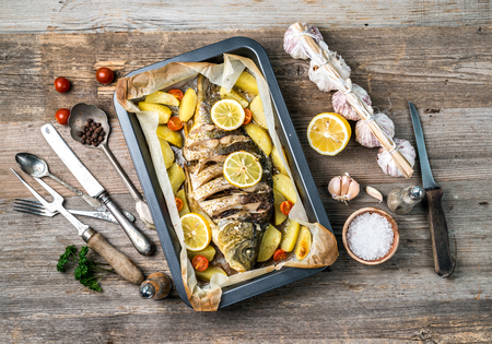 Appetizing baked fish with lemons, topviewの写真素材