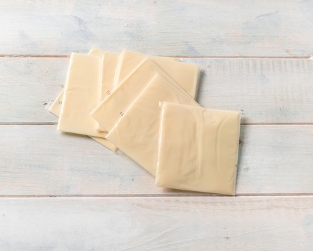 Slices of american cheddar in plastic, topshotの写真素材