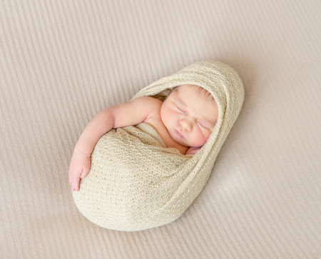 kid napping wrapped, arm hanging outの写真素材