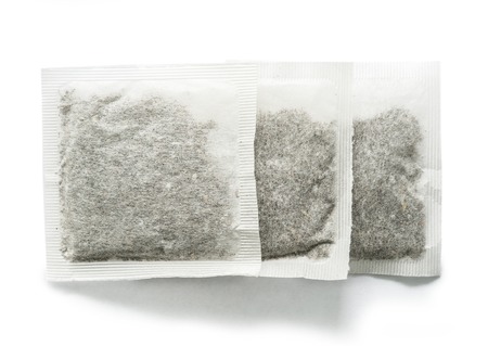 Three teabags with tea sitting on table, topviewの写真素材