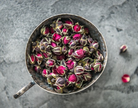 Rustic cup full of buds of dogroses, topviewの写真素材