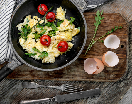 Omelette with ripe tomatoes in rustic pan, topviewの写真素材