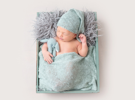 Cute baby boy sleeping in wooden boxの写真素材