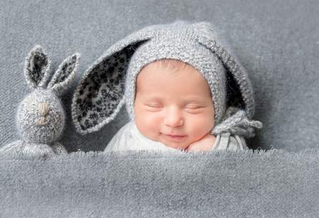 Infant baby boy sleeping under blanketの写真素材