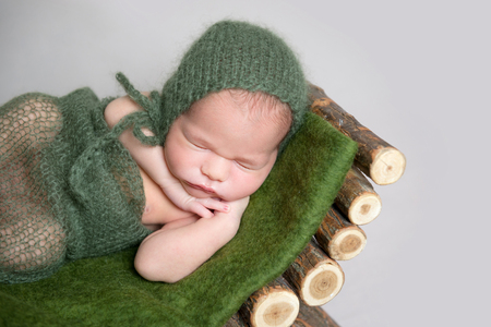 Sleeping newborn baby on wooden crib.の写真素材