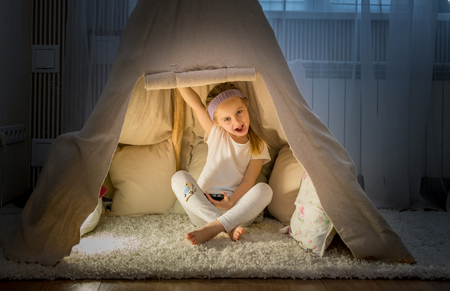 Little girl in teepee tent in roomの写真素材