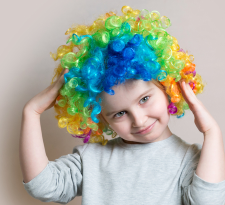 Portrait of little girl in colourful wigの写真素材