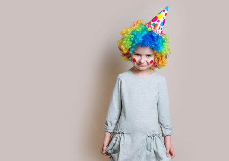 Little girl in grey dress and colourful wig