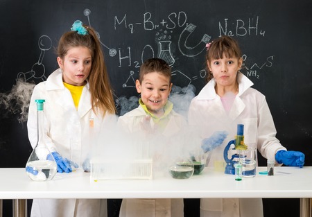 three excited children after chemical experimentの写真素材