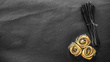Squid ink fettuccine pasta and raw pasta nestsの写真素材