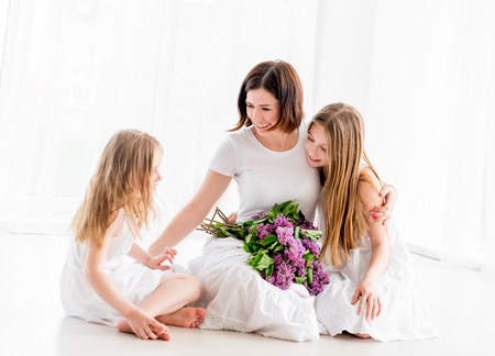 Mother and little daughter with lilac flowersの写真素材