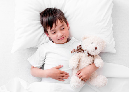 Toddler boy sleeping with teddy bearの写真素材
