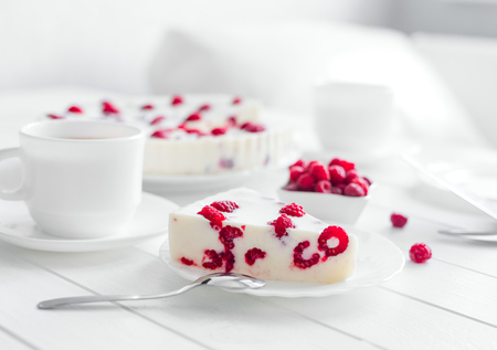 Panna cotta raspberries on a wooden white serving table.の写真素材