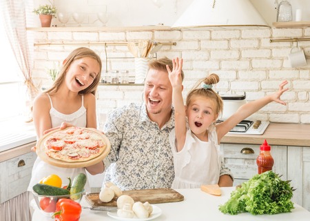 dad with daughters preparing pizzaの写真素材