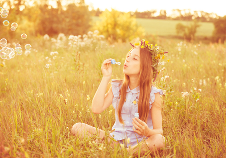 Cute little girl having fun playing with soap bubblesの写真素材