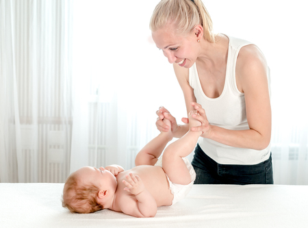 Mother massaging her infant babyの写真素材