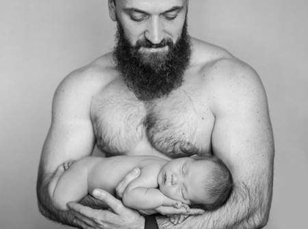 Newborn child lies on fathers hands