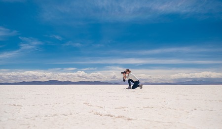 Smiling girl taking photo in sunshine Salar de Uyuniの写真素材