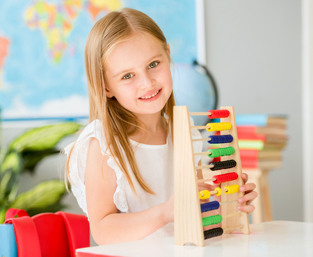 Little counting on the colourful abacus in the school classroomの写真素材