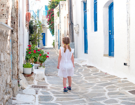 Little girl walking the narrow alley in Greeceの写真素材