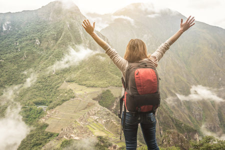 Female traveler on the top of mountain, looking on Machu Picchuの写真素材